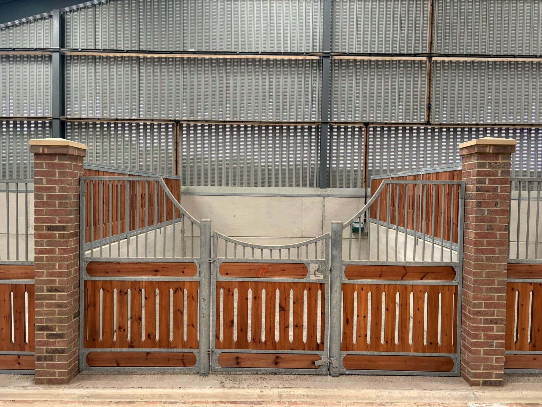The indoor stables at Tanglewood, brick pillars and timber-and-steel fronts.